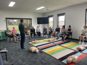 A Trainer helps a class learn CPR